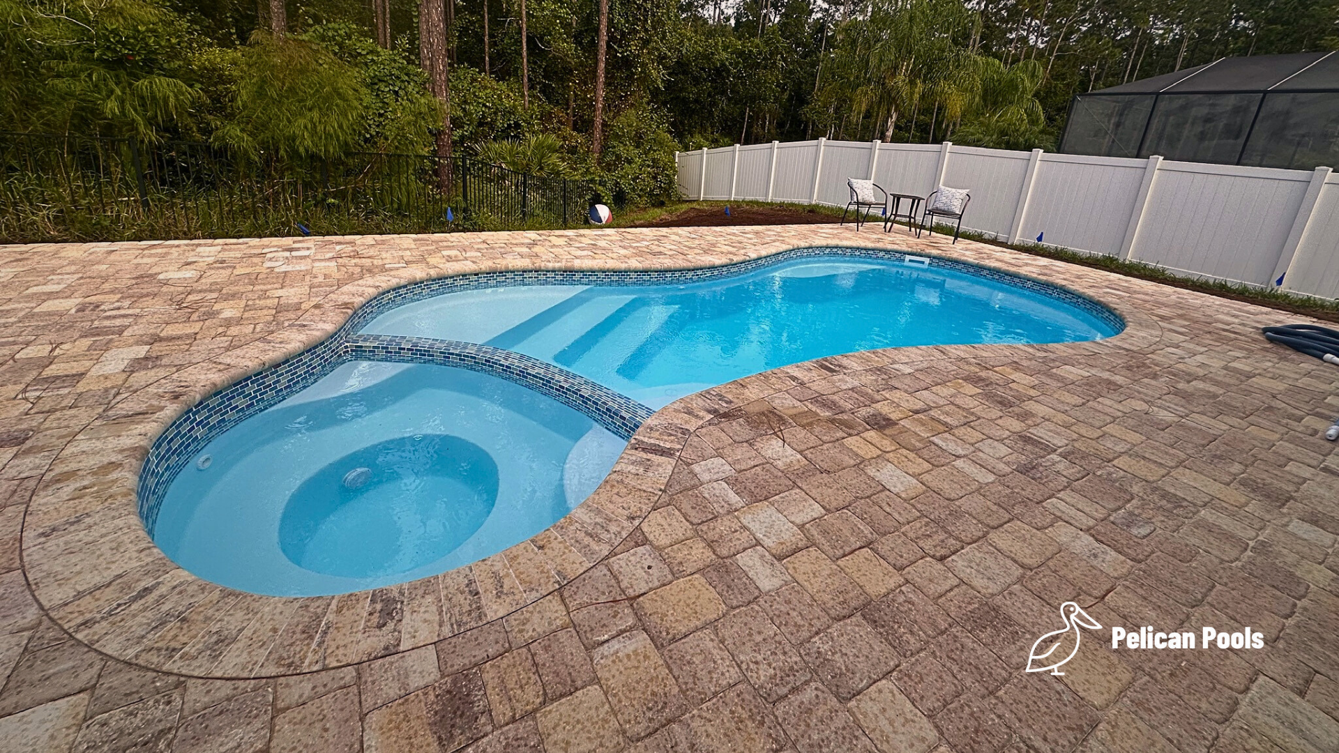 Mandalay Bay free-form fiberglass pool with attached spa, installed by Pelican Pools with fast installation for a compact backyard retreat.