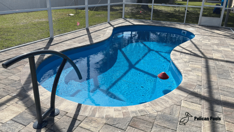 Elegant Cocoa Beach fiberglass pool installed by Pelican Pools with fast installation, offering 5,273 gallons of water, a custom relaxation bench, and plenty of space for backyard fun.