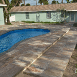 Cocoa Beach fiberglass swimming pool with bench seating and steps, installed by Pelican Pools in Volusia County with a custom paver deck.