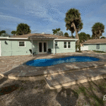 Cocoa Beach fiberglass pool with shallow end bench and relaxation area, installed by Pelican Pools in Volusia County with a custom paver deck.