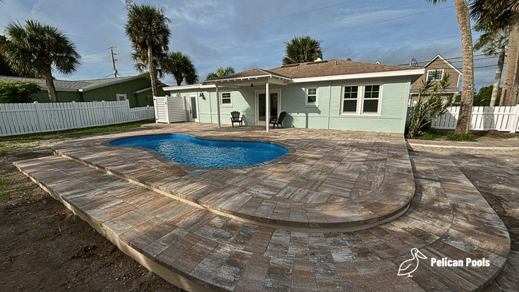 Cocoa Beach compact fiberglass swimming pool for medium-sized yards, installed by Pelican Pools in Volusia County with a custom paver deck.