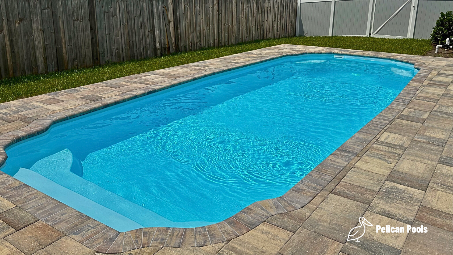 Hawaiian backyard pool with conservative deep end and two resting benches, Installed by Pelican Pools and fast installation, safe for non-diving fun.