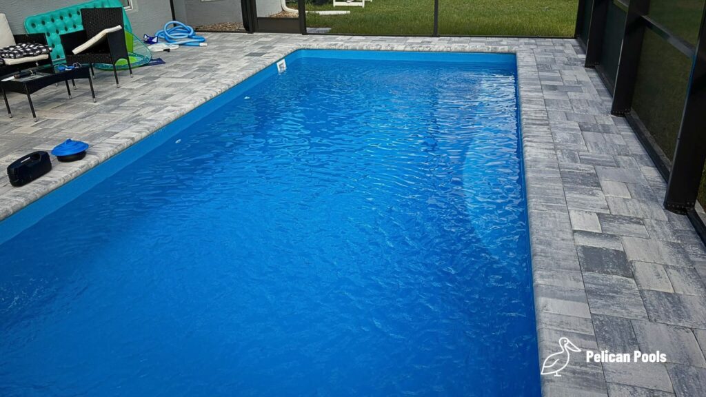 Wylela fiberglass pool installed by Pelican Pools in Palm Coast, Florida with paver deck.