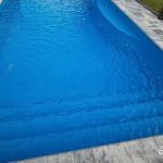 Wylela fiberglass pool installed by Pelican Pools in Palm Coast, Florida with paver deck.