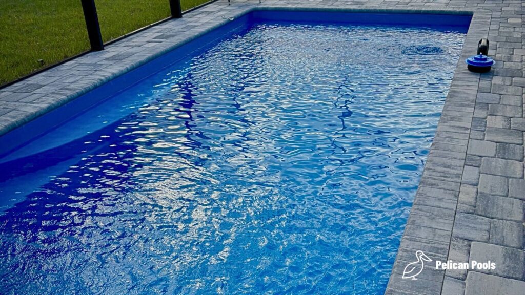 Wylela fiberglass pool installed by Pelican Pools in Palm Coast, Florida with paver deck.