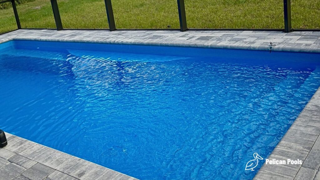 Wylela fiberglass pool installed by Pelican Pools in Palm Coast, Florida with paver deck.