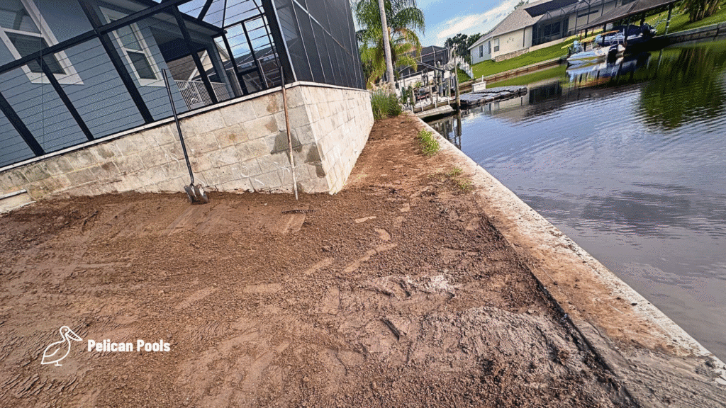 Graded backyard beside canal after pool installation.