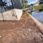 Graded backyard beside canal after pool installation.
