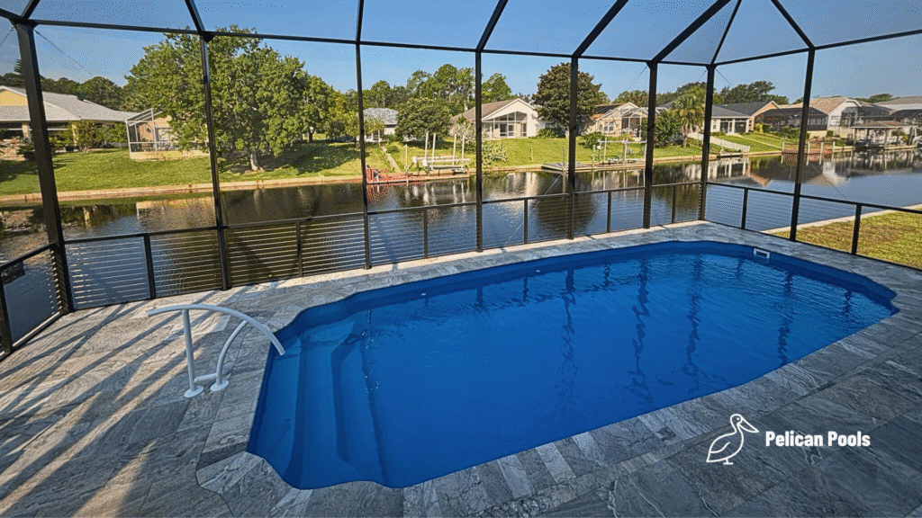 Blue fiberglass pool with screened enclosure and canal view in Palm Coast.