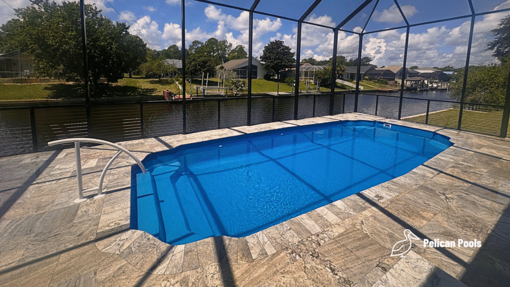 Hawaiian fiberglass pool reflecting sunlight under screened enclosure.