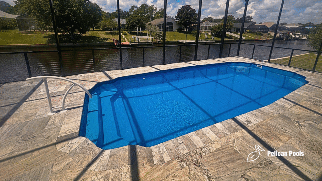 Hawaiian fiberglass pool viewed from side of screened enclosure.