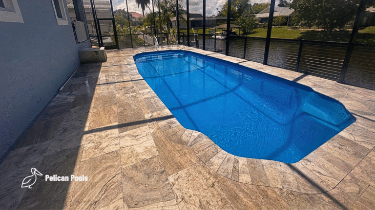 Travertine pool deck and fiberglass shell reflecting sunlight through screened lanai.
