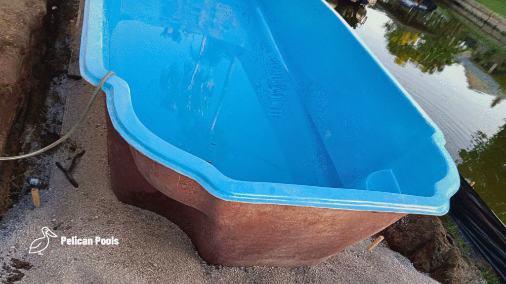Fiberglass pool partially filled with water for stabilization.