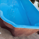 Fiberglass pool partially filled with water for stabilization.