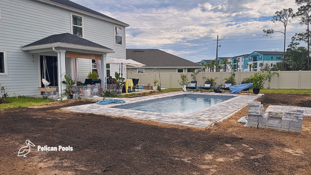 Clean, blue fiberglass pool water with finished paver deck.