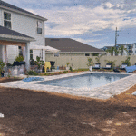 Clean, blue fiberglass pool water with finished paver deck.