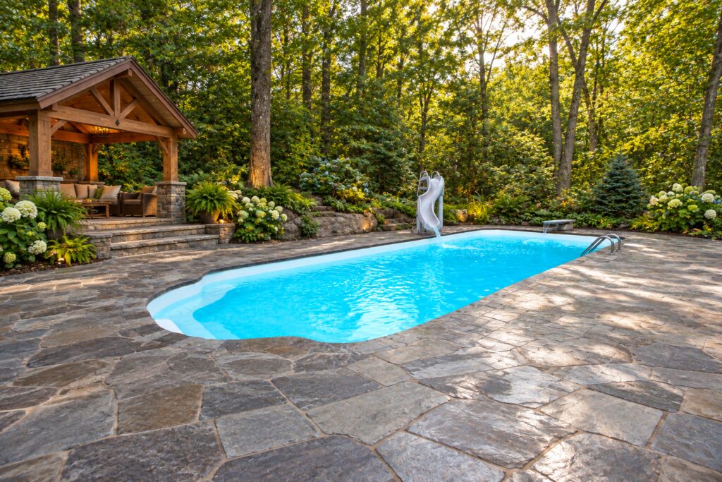 San Juan Pacific pool with curved entry steps, slide and ladder in a woodland stone patio setting