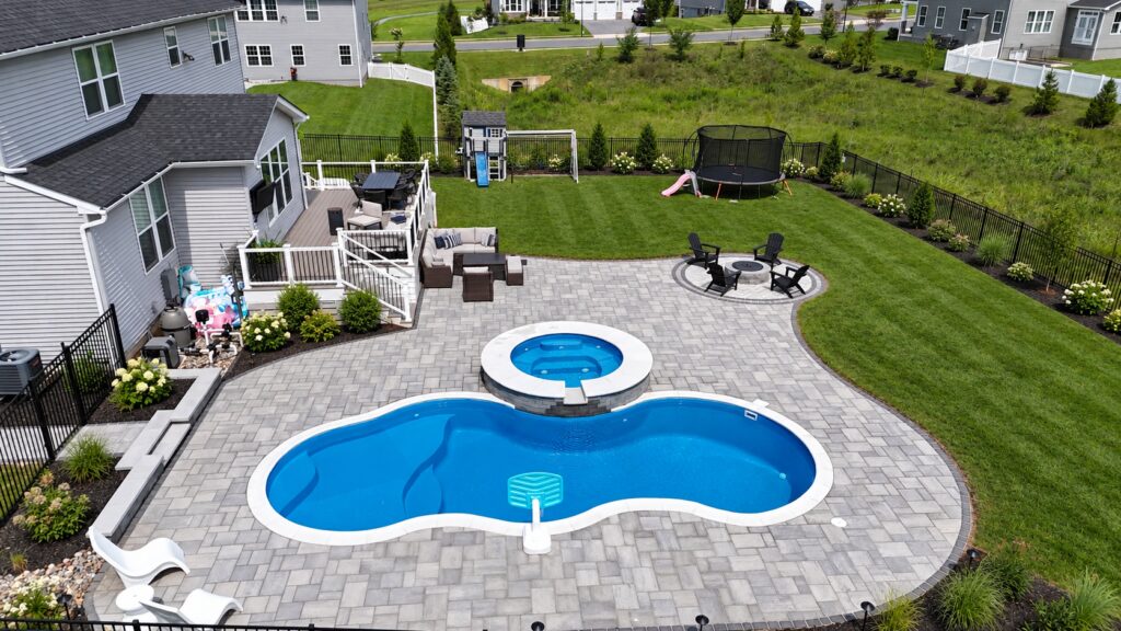 Edited design inspiration showing a Overhead view of a Costa Azul pool with raised circular spa, gray paver patio and landscaped lawn.