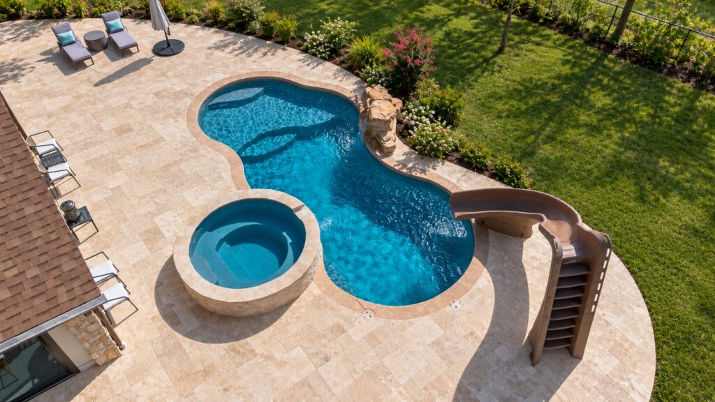 Edited design inspiration showing a Overhead view of a Costa Azul pool with slide, circular spa, rock waterfall and travertine patio.