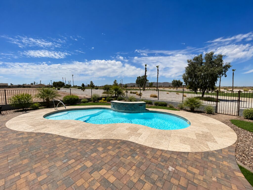 Edited design inspiration showing a Costa Azul pool with light travertine paving, curved tiled water feature and entry handrail.